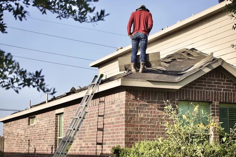 Professional roofer working on a residential roof in Thomas